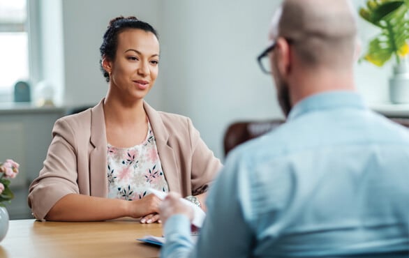 Businesswoman in a professional meeting with a colleague, discussing leadership and artificial intelligence strategies for workplace development.