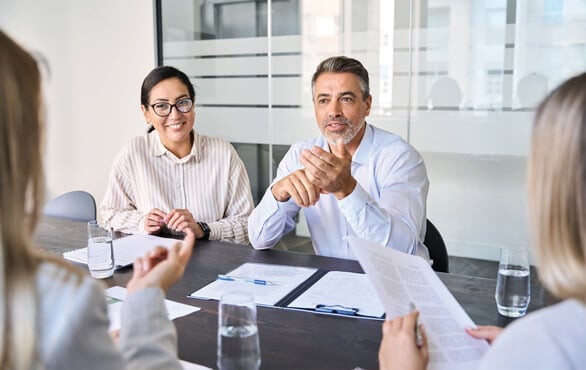 Team of business professionals in a meeting, collaborating on leadership and artificial intelligence strategies to enhance organizational performance.