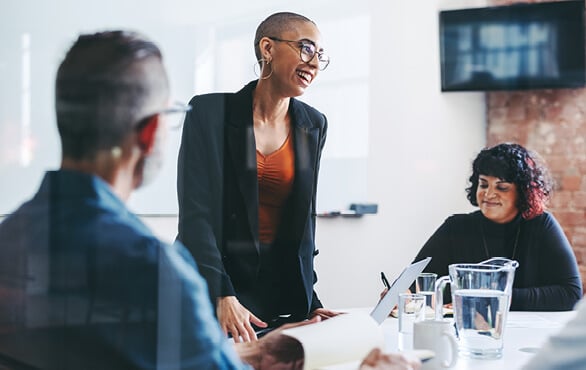 A professional woman leading a work meeting in an office.