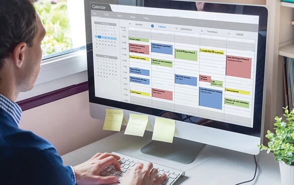 Project manager using a calendar tool to improve project management skills in a workspace.