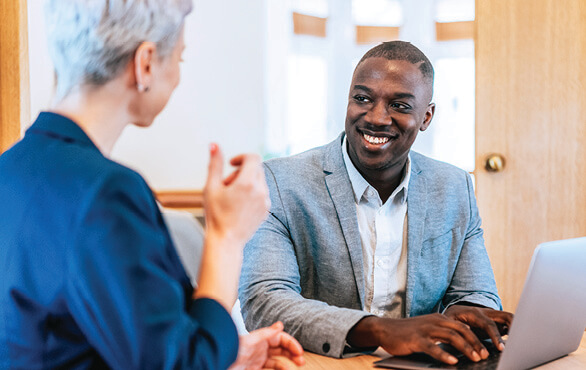 Trust-centered leadership coaching session with professionals collaborating around a laptop