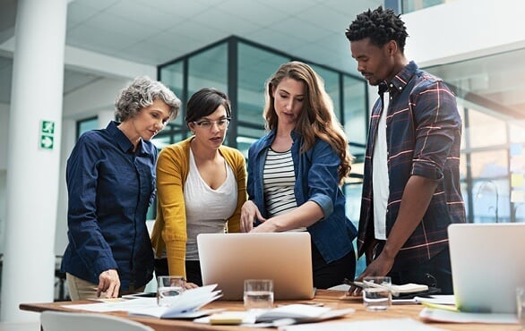 eam analyzing data on laptop during AI and digital transformation strategy meeting.