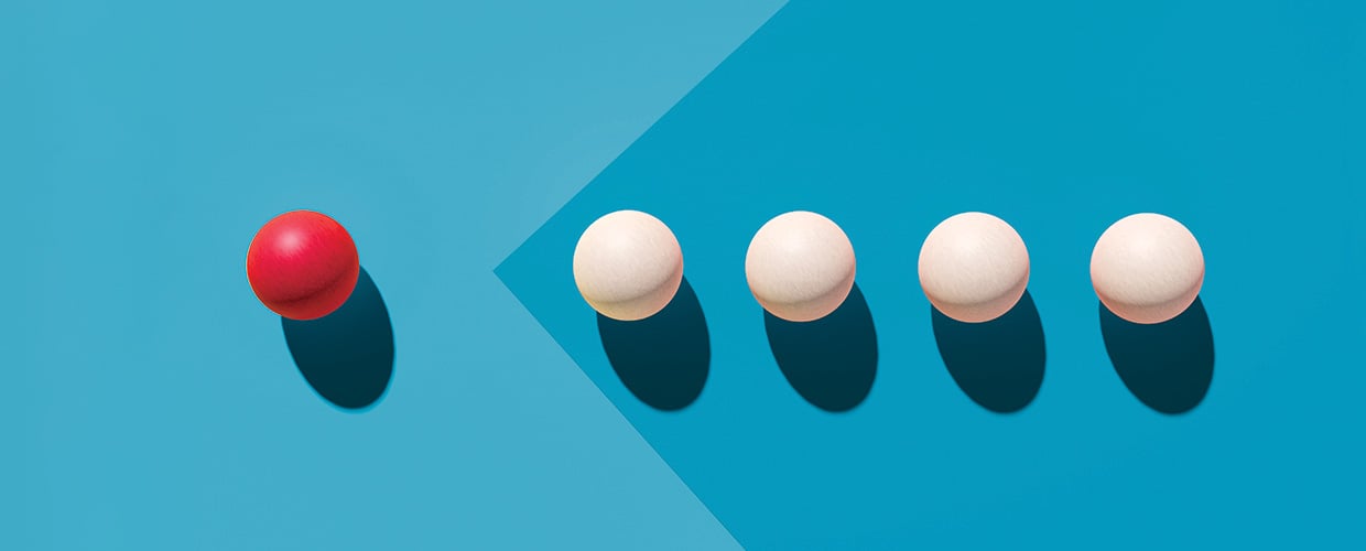 Red sphere leading four white spheres, illustrating modern leadership, influence, and standing apart from the group.