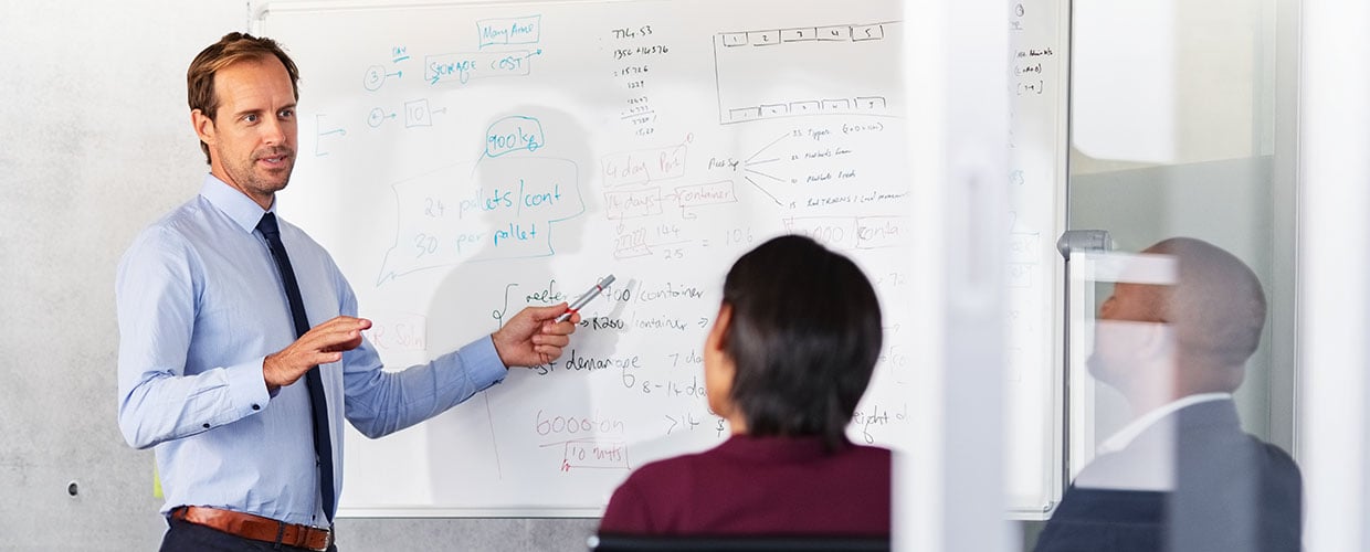 Business leader presenting strategy and leadership concepts to team members during a workplace meeting focused on communication, decision-making and organizational change.