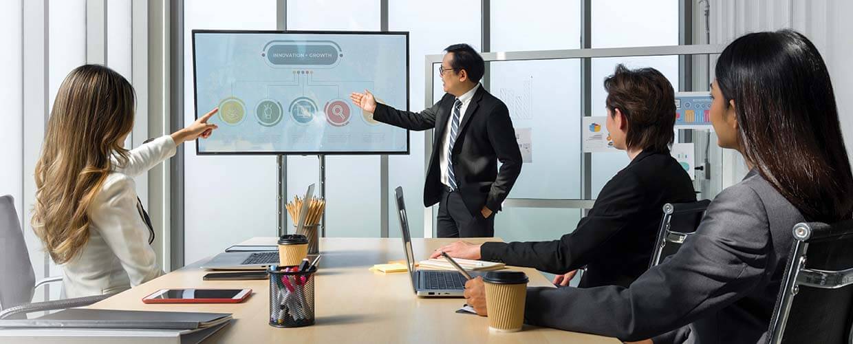 Business leader presenting innovation and growth strategies to colleagues during a workplace meeting, demonstrating collaborative leadership and creative problem solving.