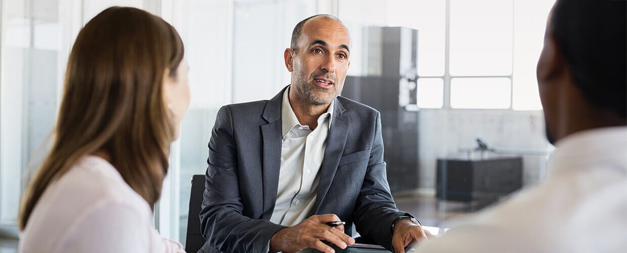 Business leader coaching team members during a one-on-one meeting focused on leadership and navigating workplace change.
