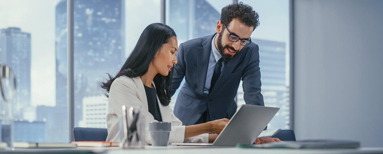 Business colleagues reviewing documents and collaborating in a professional office setting.